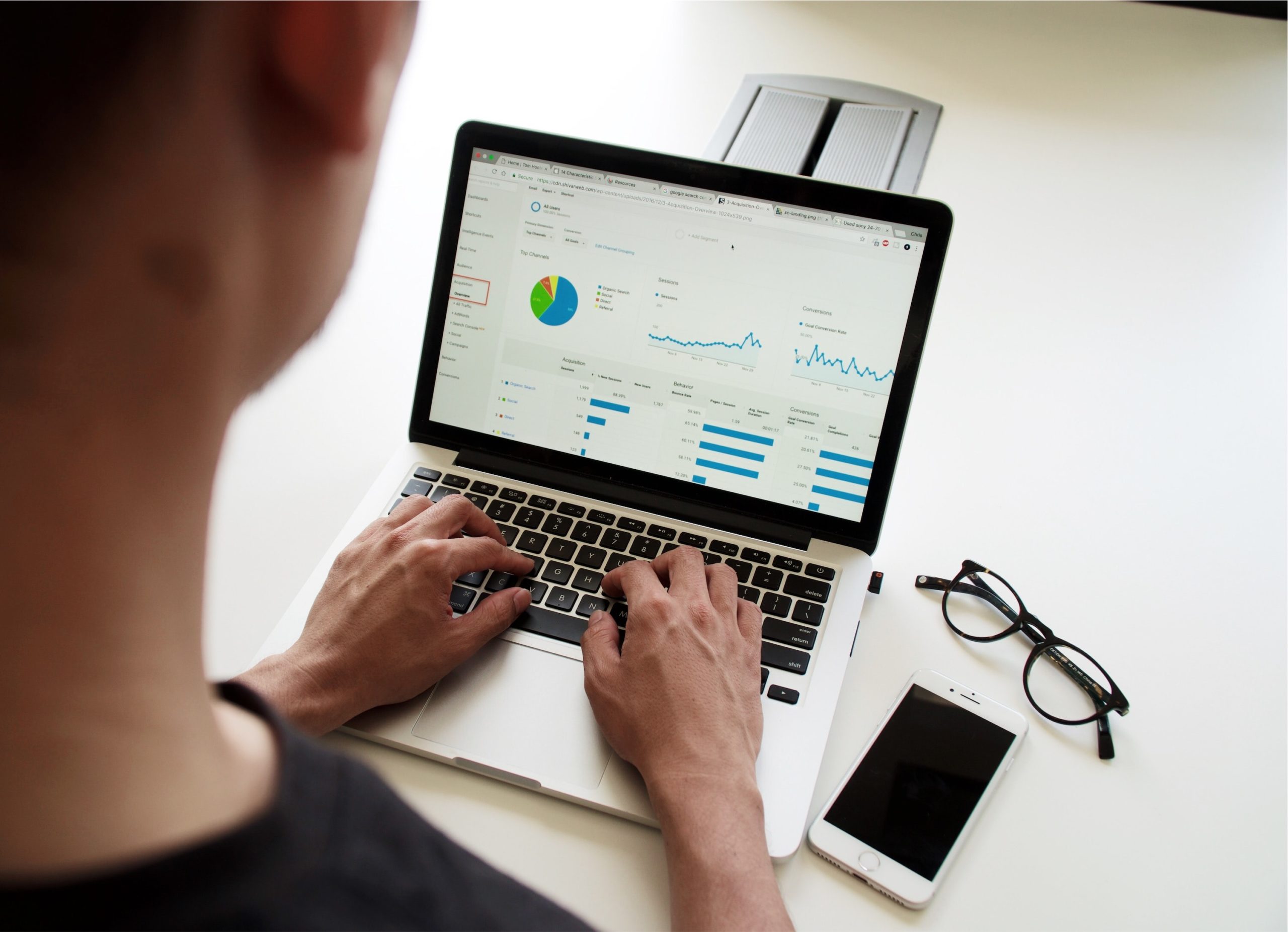 A business man works on a computer displaying data trends.