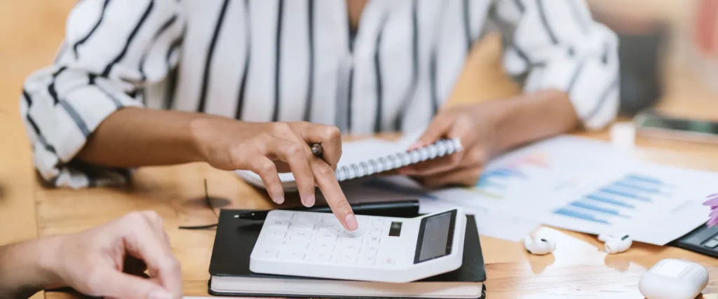 Business woman uses a calculator in an office.