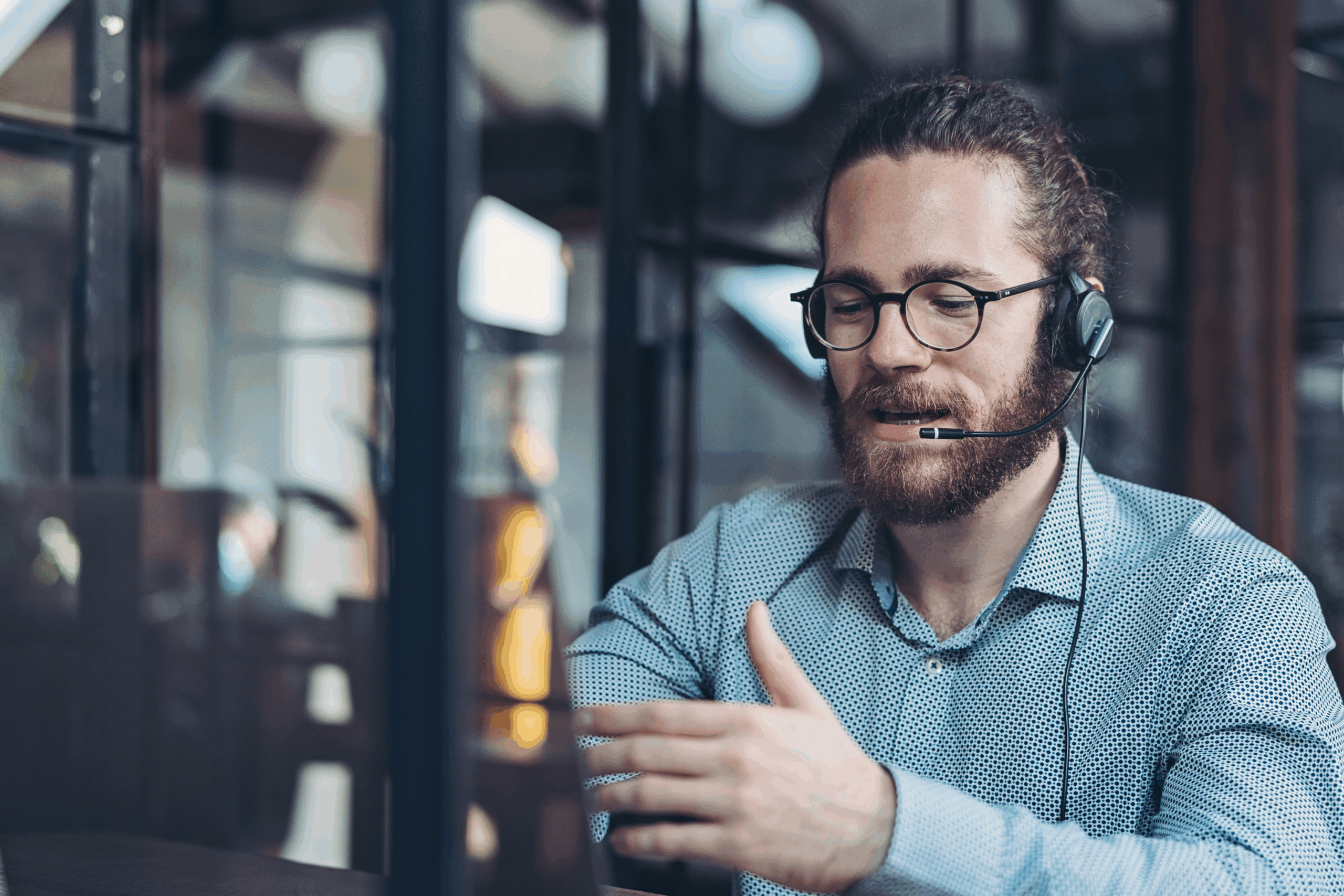 A business man with a headset is seen participating in an online meeting through his laptop.