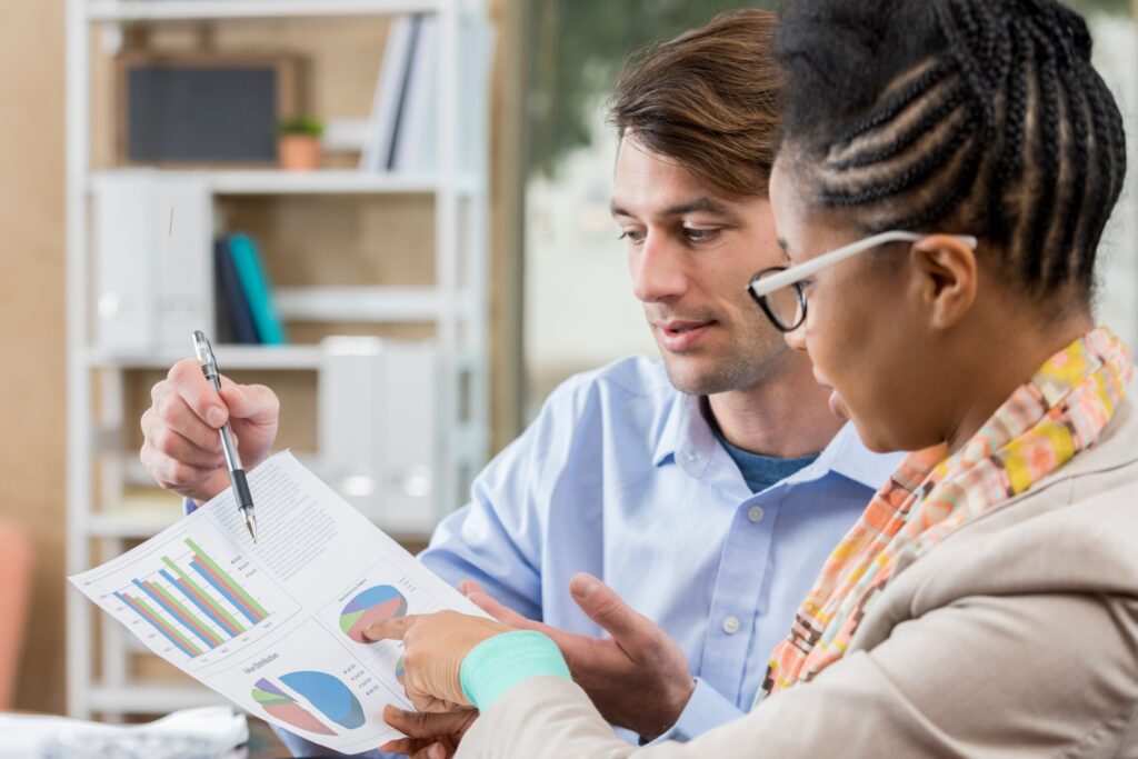 An accountant reviews accounts with a business owner in an office.