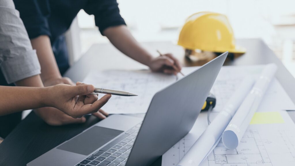 Two construction business owners go over financial data at a desk.