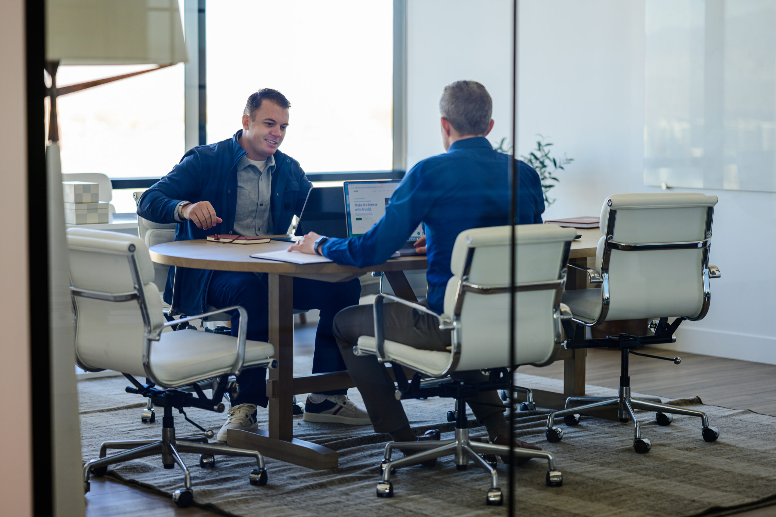 Co-Founder Shane Rowley and Tax Lead Shawn Bean meet in an office.
