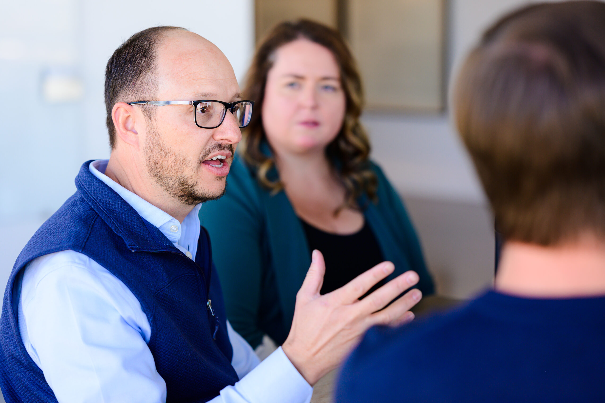 Nimbl experts have a conversation around a table in an office building.
