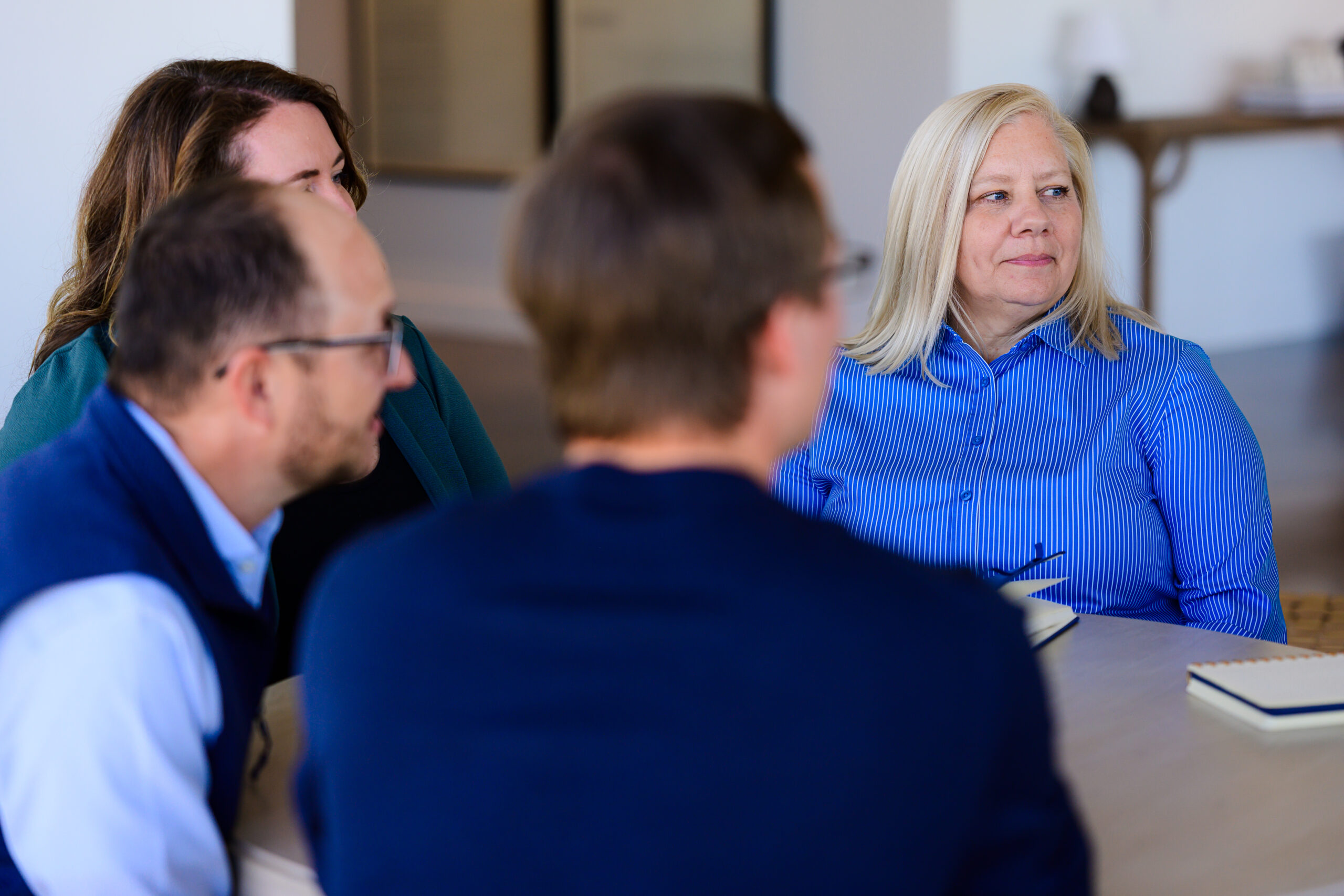 Nimbl experts have a conversation around a table in an office building.