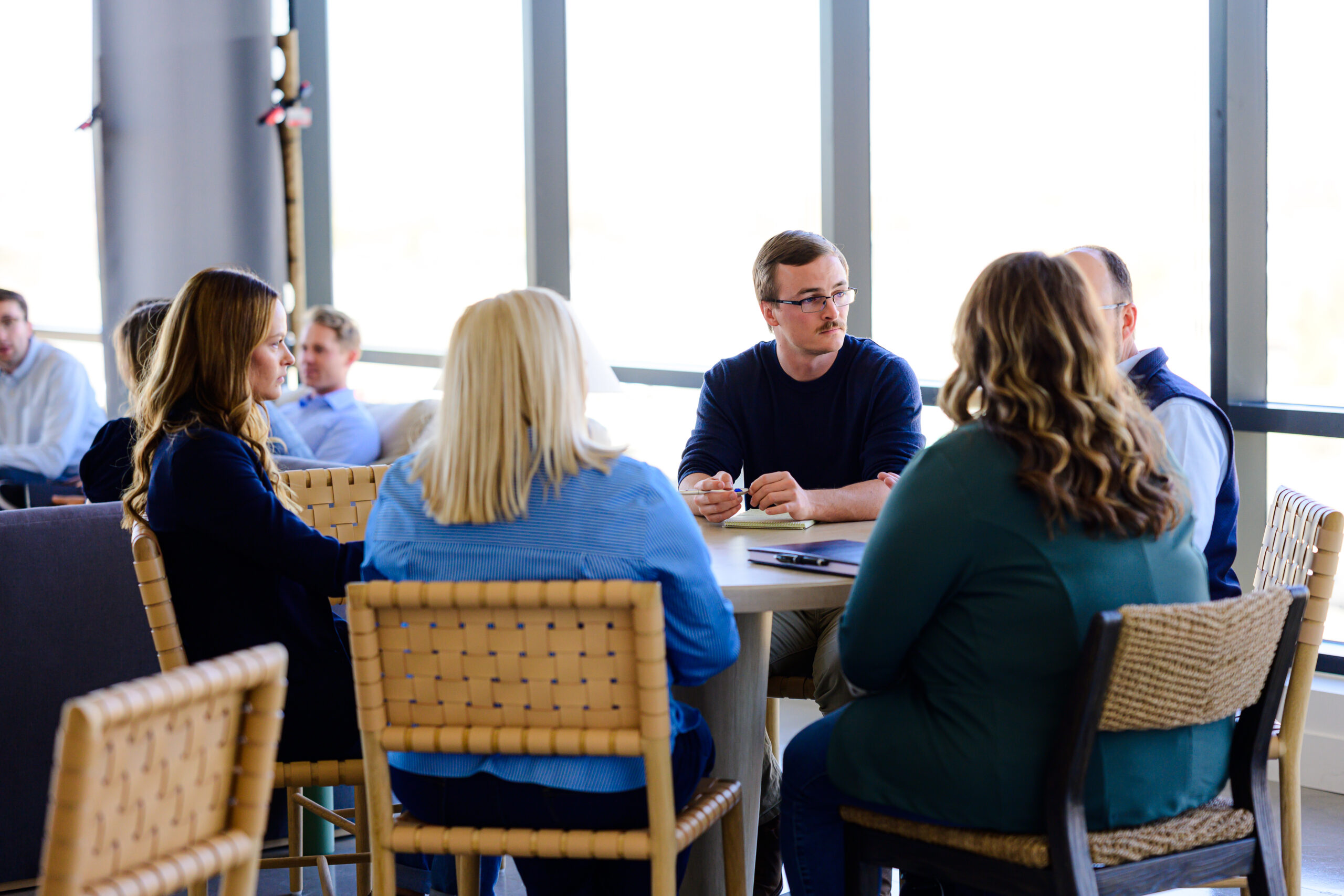Nimbl experts have a conversation around a table in an office building.