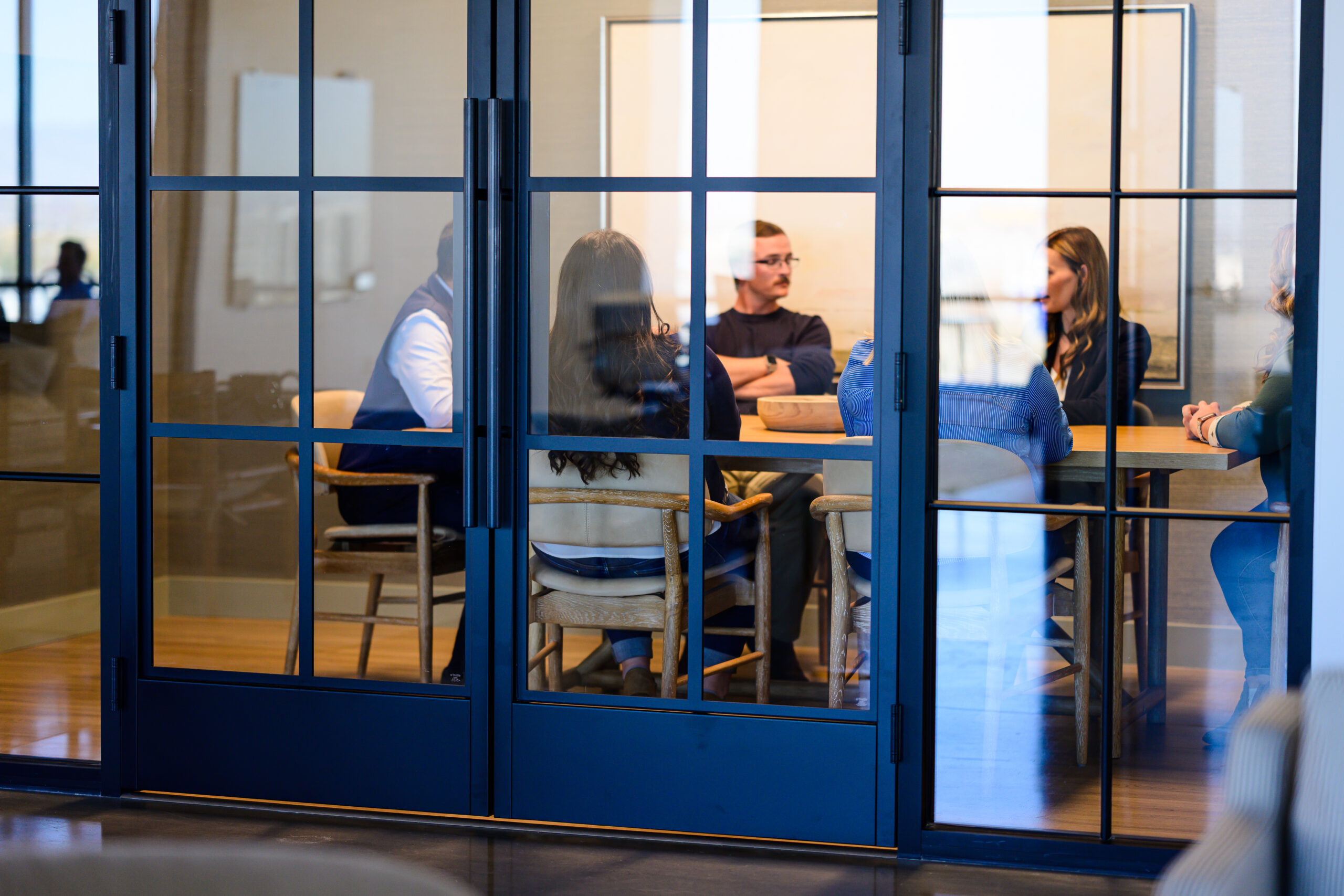 A company leadership team is seen meeting around a conference table.