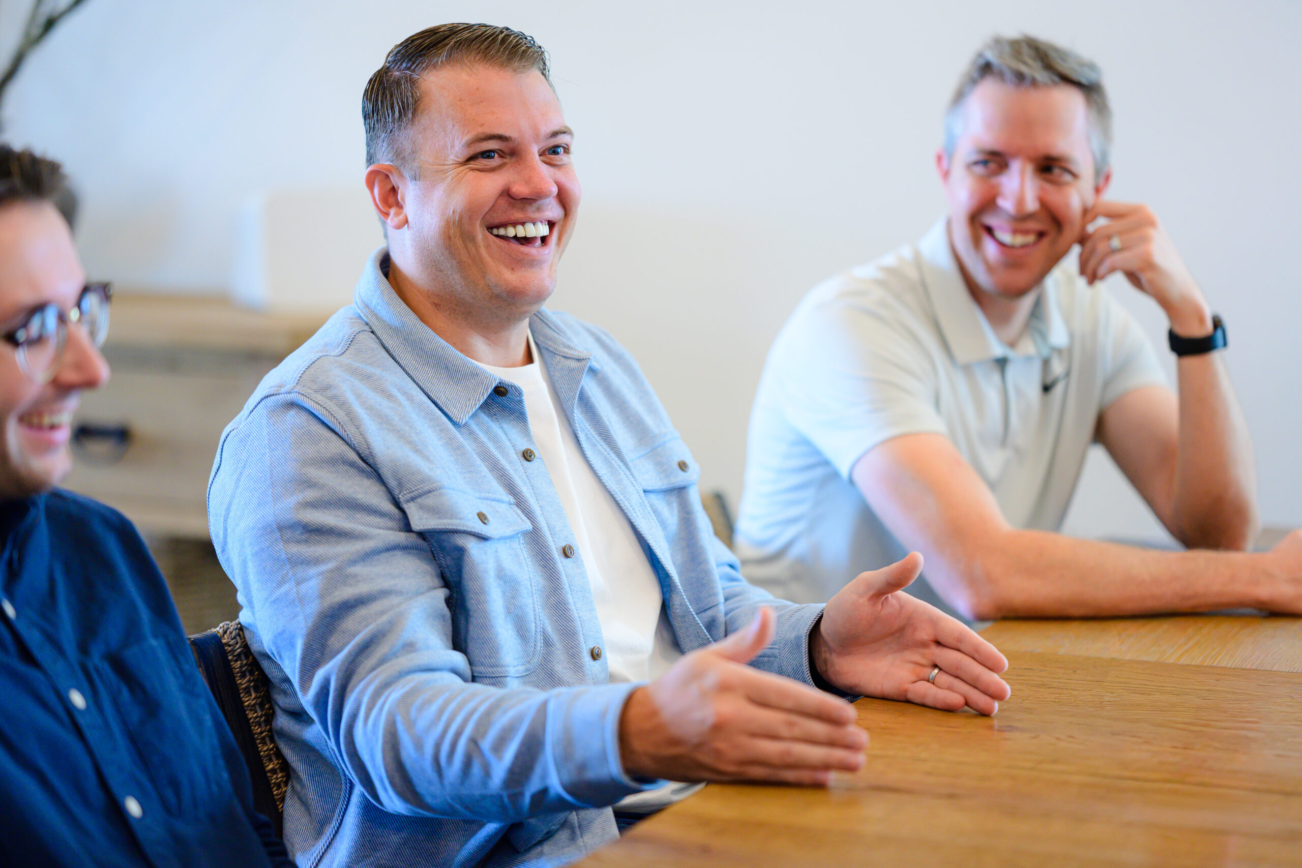 The Nimbl team laughs around a table at the Nimbl office.