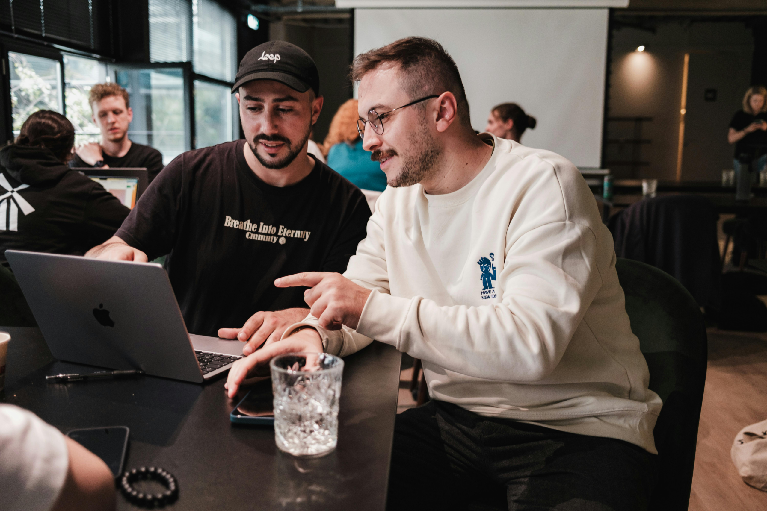 Two young male business owners deliberate in an office.